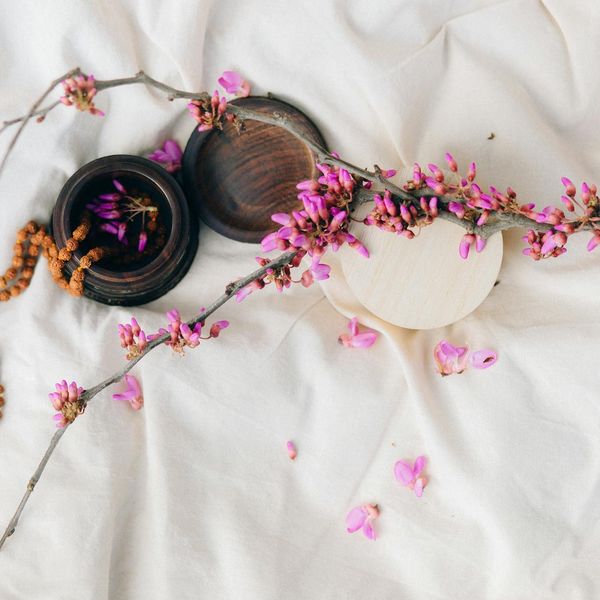 Woman in a peaceful yoga pose against a soft, linen-colored background.